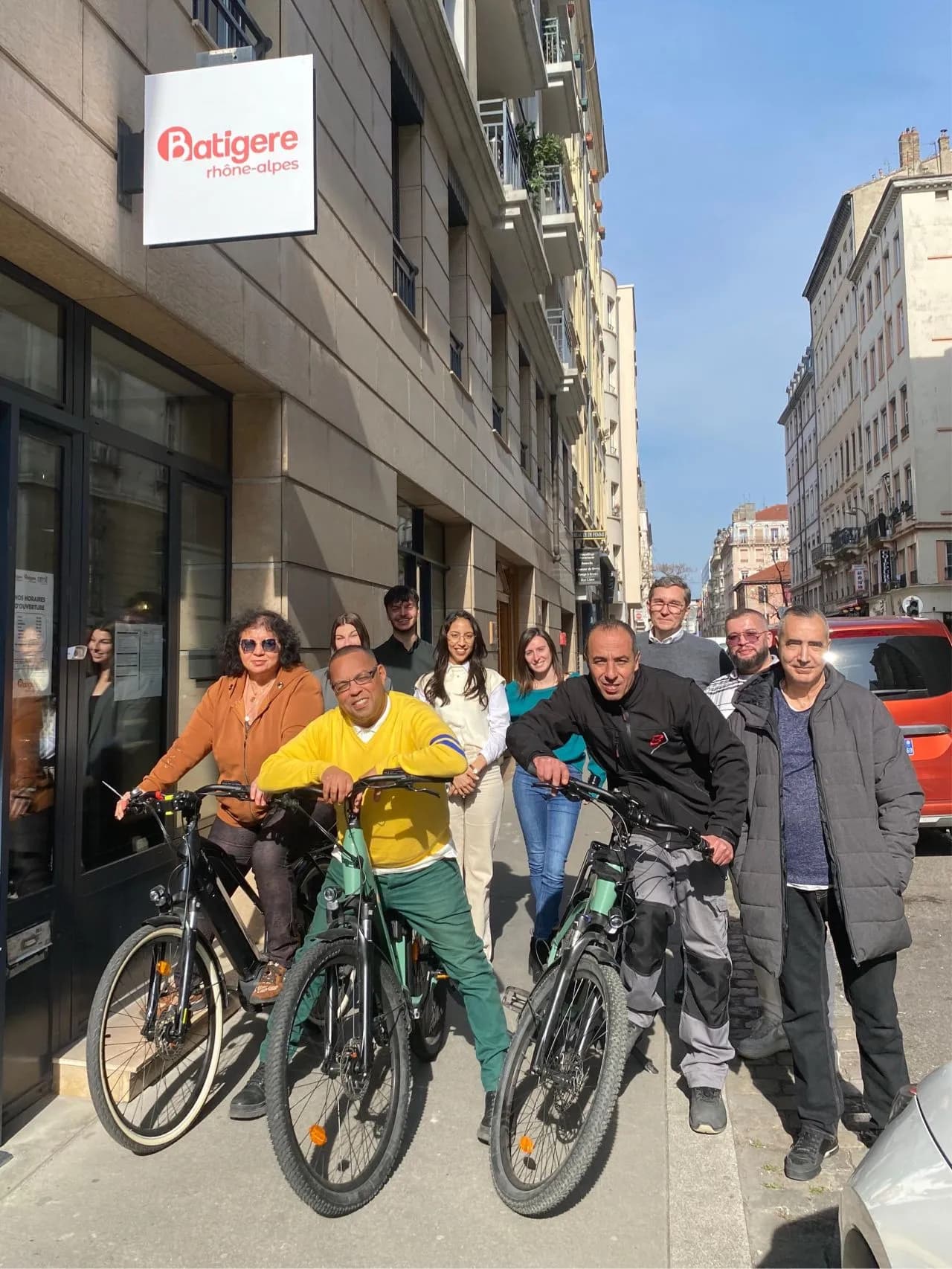 Une équipe d'une dizaine de personnes pose dans la rue avec des vélos, chez Batigère.