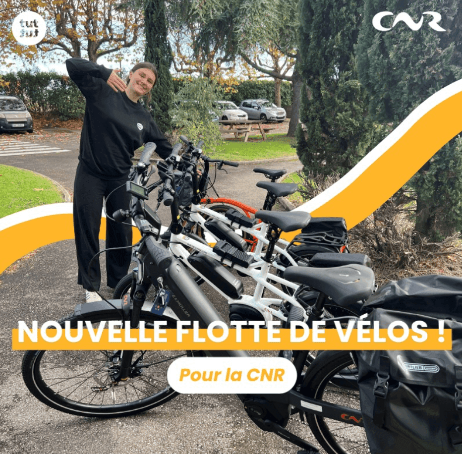 Young woman smiles while standing next to a rack of new electric bicycles.